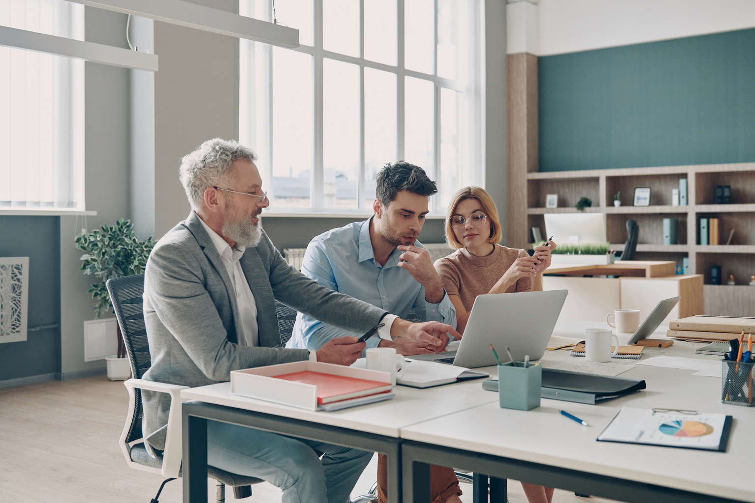 Three business people having discussion while working in the office together