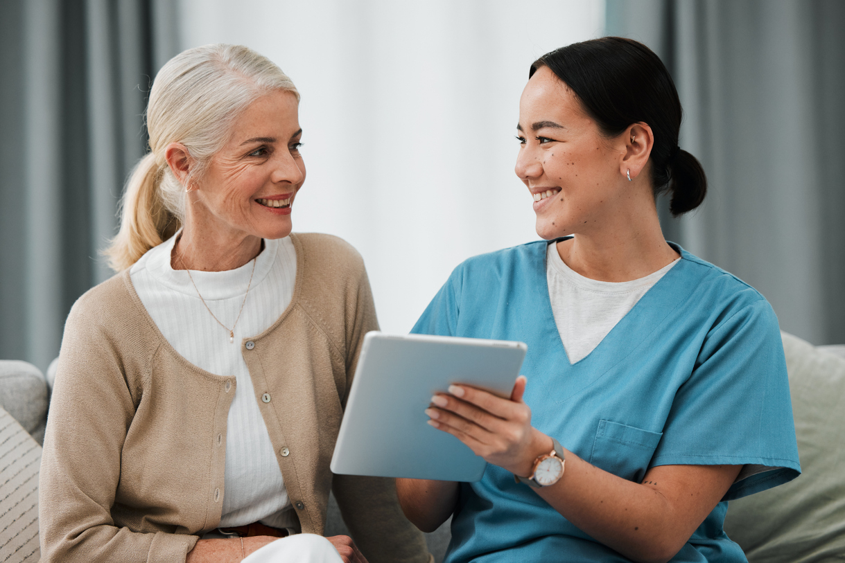Nurse providing in-home care reviews care instructions on a tablet device