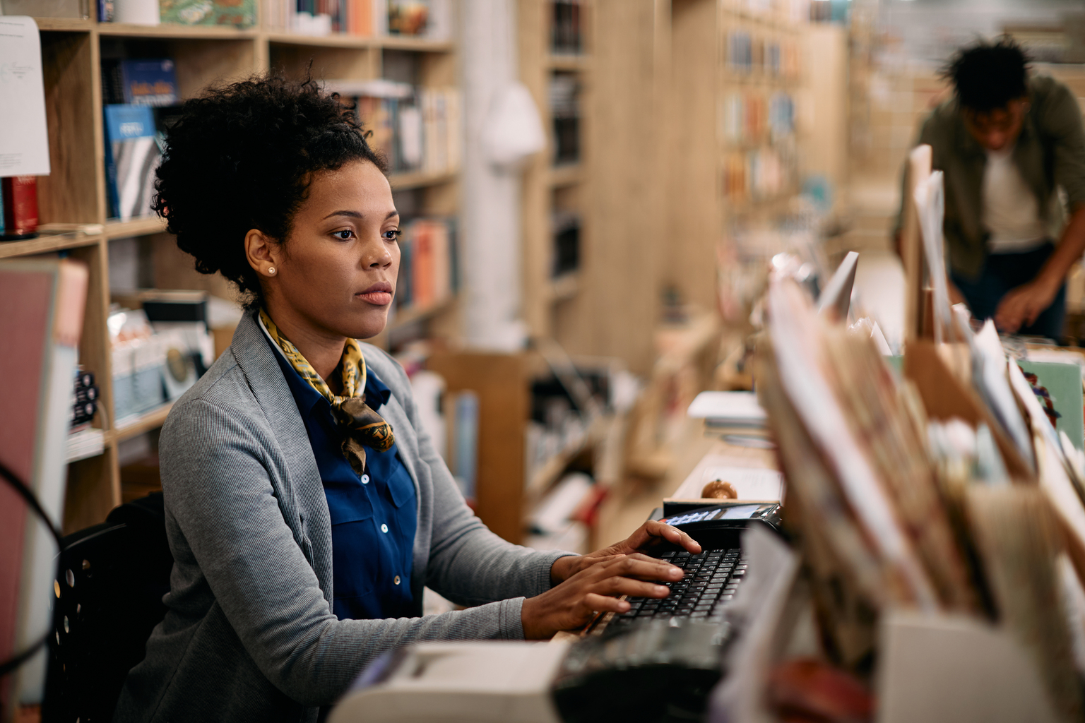 African American woman using desktop PC while working in library